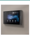 Akuvox S565W grey indoor monitor mounted on a living-room wall