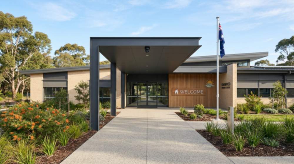 Modern Australian primary school front entrance with paved pathways, a welcome sign, and a discreet PoE bullet CCTV camera mounted under the entry canopy
