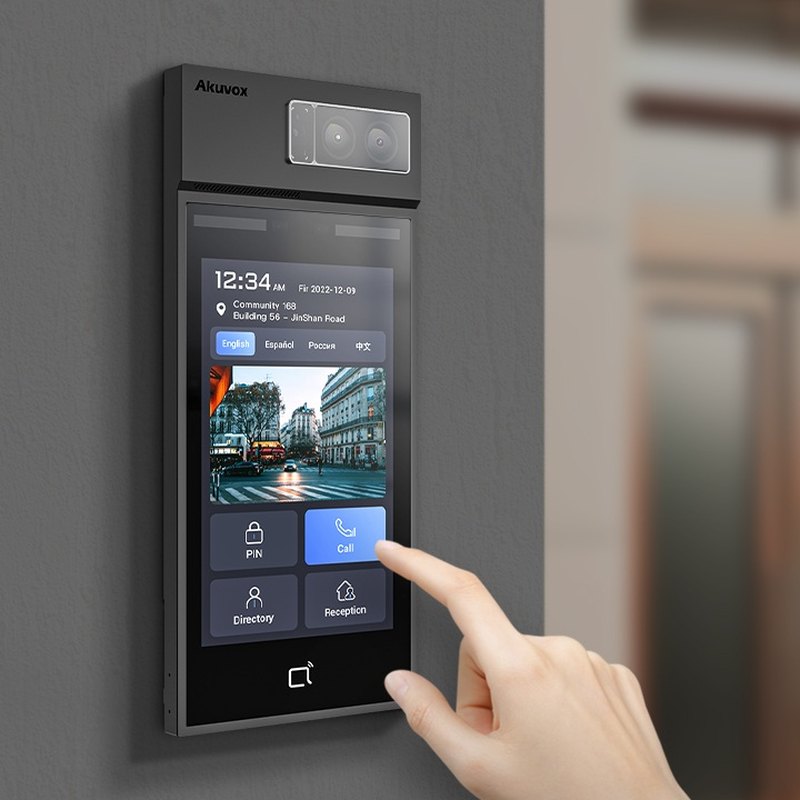 Hand touching the Akuvox S538 8-inch screen on an entrance wall