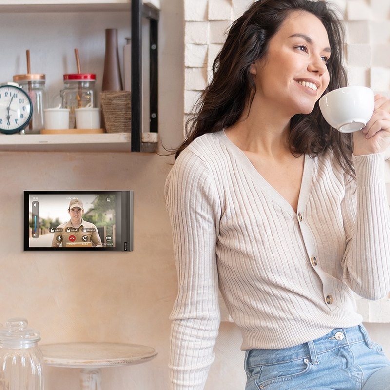 Resident at home with an Akuvox S563 indoor monitor on the wall