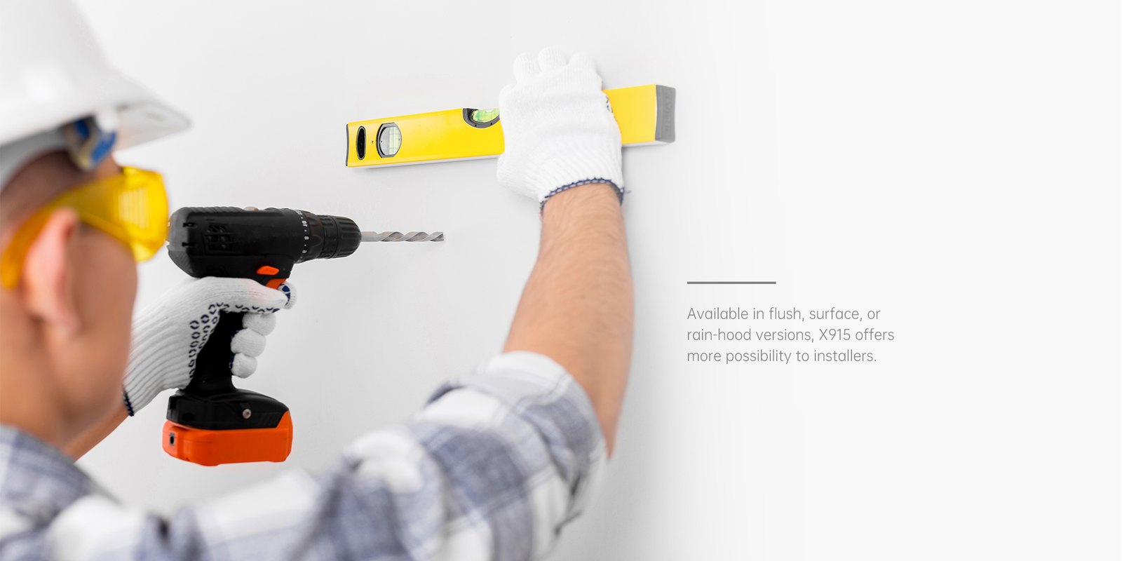Installer drilling a wall to mount an Akuvox X915