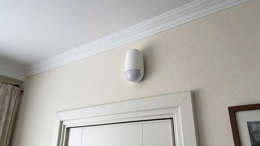 Wireless motion detector mounted above a hallway door